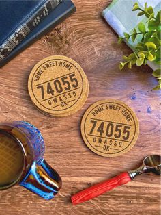 three personalized coasters on a wooden table next to a cup of tea and books