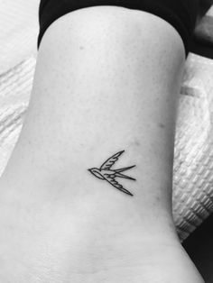 a black and white photo of a small tattoo on the ankle