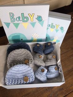 there is a box that has some crocheted baby items in it, including shoes and booties