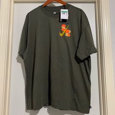 Loose Fit 100% Cotton Casual Nike Orange Tops, Casual Orange Nike Tops, Nike Casual Orange Tops, Casual Green Nike T-shirt, Nike Orange Short Sleeve Tops, Green Nike T-shirt For Streetwear, Casual Green T-shirt With Side Pockets, Nike Green Short Sleeve T-shirt, Nike Orange Crew Neck T-shirt