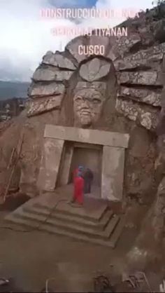 an aerial view of a building made out of rocks and stonehenge with a person standing in the doorway