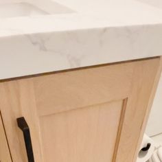 a bathroom vanity with marble top and wooden cabinet