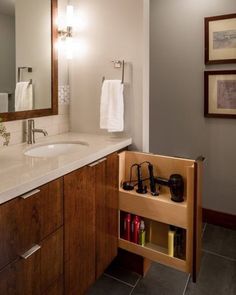 a bathroom with a sink, mirror and towel rack on the counter in front of it