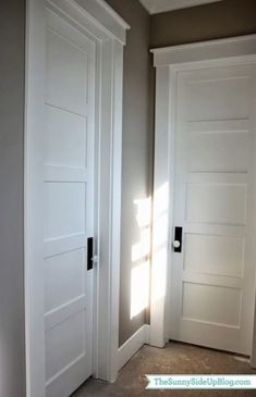 an empty room with two white doors in it