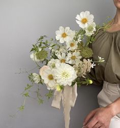 a woman holding a bouquet of white flowers