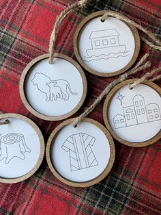 four wooden ornaments with hand drawn animals on them