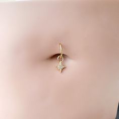 a gold ring with a star charm on it's side, sitting on top of a mannequin