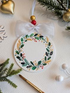 This hand-painted wooden Christmas ornament features a orange, green, gold, and white wreath design. Perfect for adding a festive touch to your holiday decor, it's lightweight with a ribbon for easy hanging. The ornament is unique and makes a great gift or addition to your own Christmas tree. Size:  9.5 cm x 9.5 cm (3.7 inch x 3.7 inch) More of my beautiful handcrafted Christmas ornaments can be found here:  https://www.etsy.com/shop/laviecolor/?etsrc=sdt§ion_id=50916106 This is an original pain Easy Painted Ornaments, Handcrafted Christmas Ornaments, Wreath Ornaments, Paint Inspo, Wreath Ornament, Wreath Drawing, White Wreath, Custom Christmas Ornaments, Christmas Wood Crafts