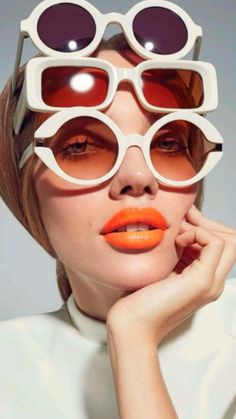 a woman with orange lipstick and sunglasses on her face