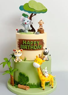 a birthday cake decorated with animals and trees