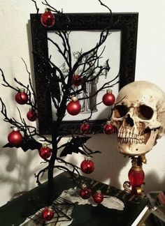 a skull sitting on top of a table next to a tree with red balls in it