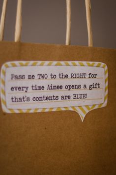 a brown paper bag with a quote on the tag that says pass me two to the right for every time aime opens a gift that's contents are blue