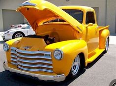 an old yellow truck with its hood open