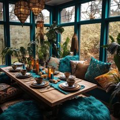 a dining room table set with plates and place settings in front of a large window