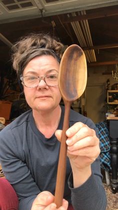 a woman holding a wooden spoon in her hands