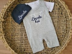 "This summer baby boy coming home outfit is a very soft cotton/poly blend and is perfect for warm summer temperatures! We are currently offering this outfit in the 0-3 Mo size only. This outfit makes a wonderful gift or hospital outfit. The separate short-sleeve t-shirt is white and compliments the white and navy embroidered monogram on the sleeveless, grey, short pant romper. This romper has snaps in the back. It also includes an navy beanie with a gray embroidered name. Please be sure to inclu Gray Cotton Onesie For Loungewear, Personalized Cotton Onesie For Summer, Personalized Cotton Onesie For Loungewear, Summer Coming Home Outfit, Pant Romper, Baby Boy Coming Home Outfit, Navy Beanie, Boy Coming Home Outfit, Baby Boy Summer