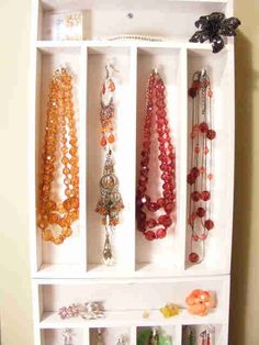 a white shelf filled with lots of necklaces