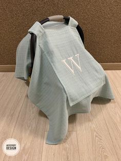 a chair covered in a blanket with the letter w on it's back end