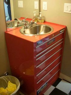 a bathroom with a sink, mirror and checkered floor