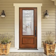 two planters with plants are in front of the door