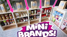 an assortment of mini brands on display in a store with pink arrows pointing to them