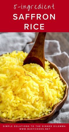 a wooden spoon filled with saffron rice on top of a white table cloth