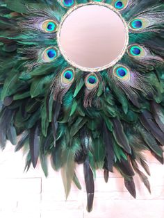 Jujuhat Peacock feathers and Rooster feathers ✋ Made by hand and with love in my small workshop located in the Grand Est in France 🇫🇷 💫 Natural rooster feathers dyed green and peacock feathers ✨ Mirror 15cm in diameter for a model 60-70cm in diameter (The size of the mirror changes depending on the diameters in order to provide a homogeneous result) 🌟 Gold jute edging the mirror ⭐️ Strong and durable support A small hook is provided at the back to install it as soon as you receive it! ❗️Feat Wreath Mirror, Juju Hat, Peacock Tail, Rooster Feathers, Grand Est, Feather Crafts, Tail Feathers, Peacock Feathers, Jewel Tones