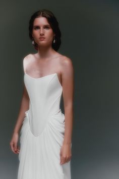 a woman in a white dress posing for a photo