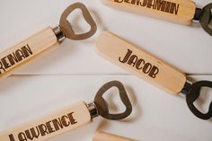 four wooden bottle openers with names on them