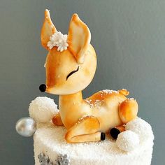 a cake decorated with a little deer laying on top of it