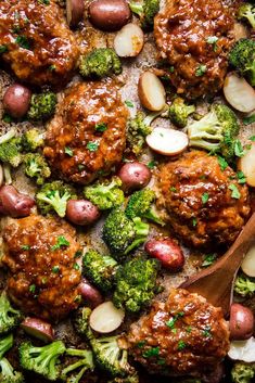 meatballs and broccoli in a casserole dish with a wooden spoon