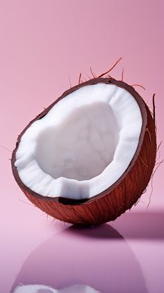 a half eaten coconut sitting on top of a pink surface