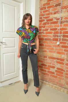 Brighten up your wardrobe with this Vintage 80s Tie Waist Blouse featuring a vibrant abstract print. This blouse combines retro charm with a modern twist, showcasing a unique color palette and eye-catching patterns. The tie waist design adds a flattering silhouette, perfect for pairing with high-waisted jeans or skirts. Sized for S/M, this blouse is a versatile statement piece that's ideal for adding a pop of color to any outfit. - Label: Jacqueline Eve - Era: 1980s - Color:multi color - Fabric: Casual Multicolor Blouse With Vintage Print, Multicolor Retro Blouse With Retro Print, Retro Multicolor Tops With Abstract Print, Trendy Multicolor Blouse With Retro Print, Retro Multicolor Abstract Print Tops, Retro Green Blouse With Graphic Print, Casual Multicolor Blouse With Retro Print, Colorful Retro Print Tops, Retro Multicolor Graphic Print Blouse