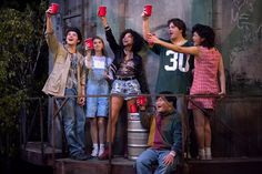 group of young people holding up red cups