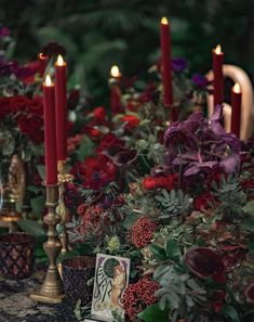 candles are lit in front of flowers and pictures