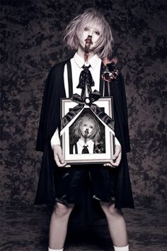 a woman in black and white dress holding a framed photo