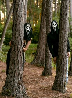 two people wearing masks standing in the woods