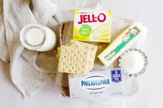 some crackers, milk and other items are on a plate next to a napkin