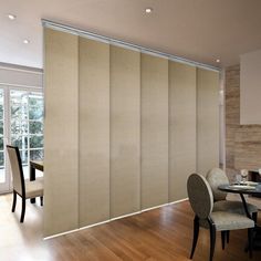 a dining room with sliding glass doors in the center and wooden flooring on the other side