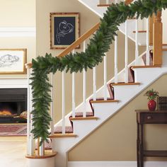 christmas garland on the banisters and stairs in front of an open fire place