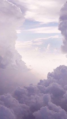 an airplane is flying high in the sky with clouds around it and some planes on the ground