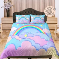 a bed with rainbows, clouds and stars in the sky on top of it