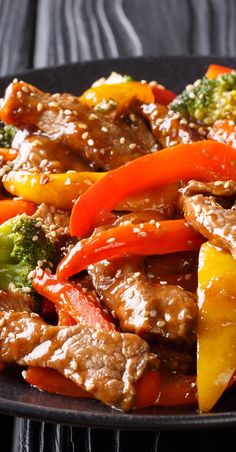 a plate with beef, broccoli and peppers in sauce on top of it