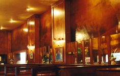 the interior of a restaurant with wood paneling and wooden bar stools on either side