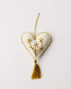 a heart shaped ornament with flowers and tassels