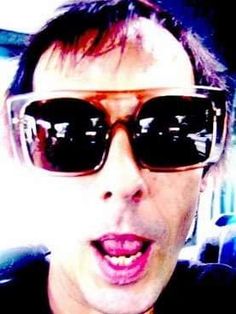 a close up of a person wearing sunglasses and making a face with his tongue out