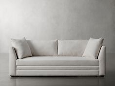 a white couch with two pillows on it