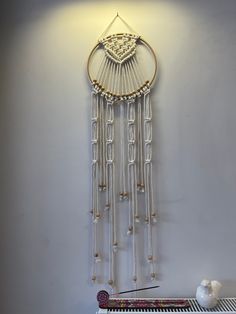 a wall hanging with beads and chains on it