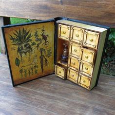 an open book with drawers inside on a wooden table