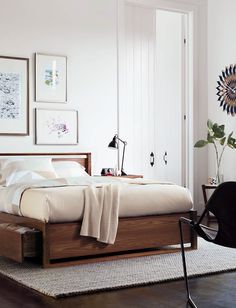 a bedroom with white walls and pictures on the wall